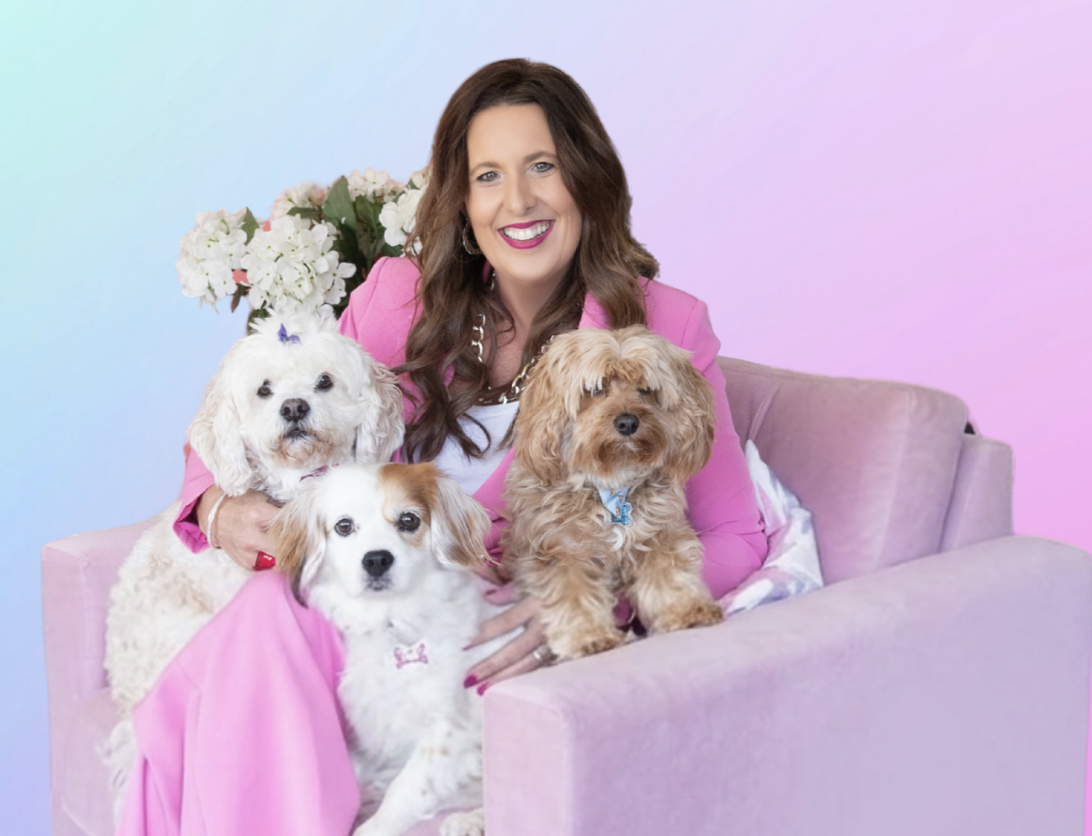 Tanya with her dogs on a pink sofa